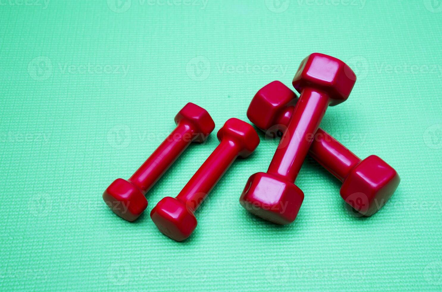 small dumbbells on green background photo