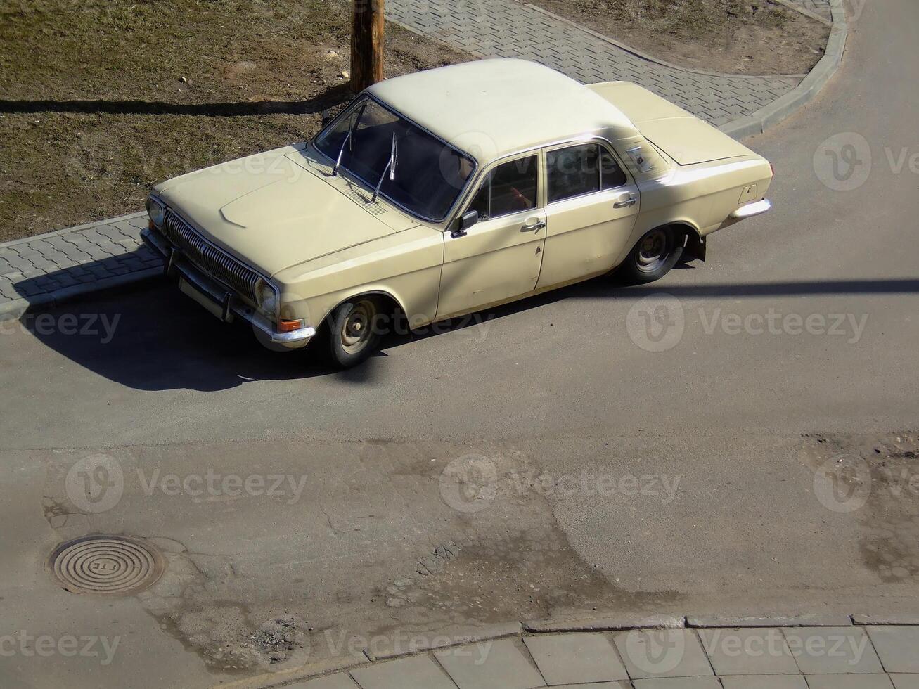 Vintage sedan parked on a quiet street corner during daylight hours photo