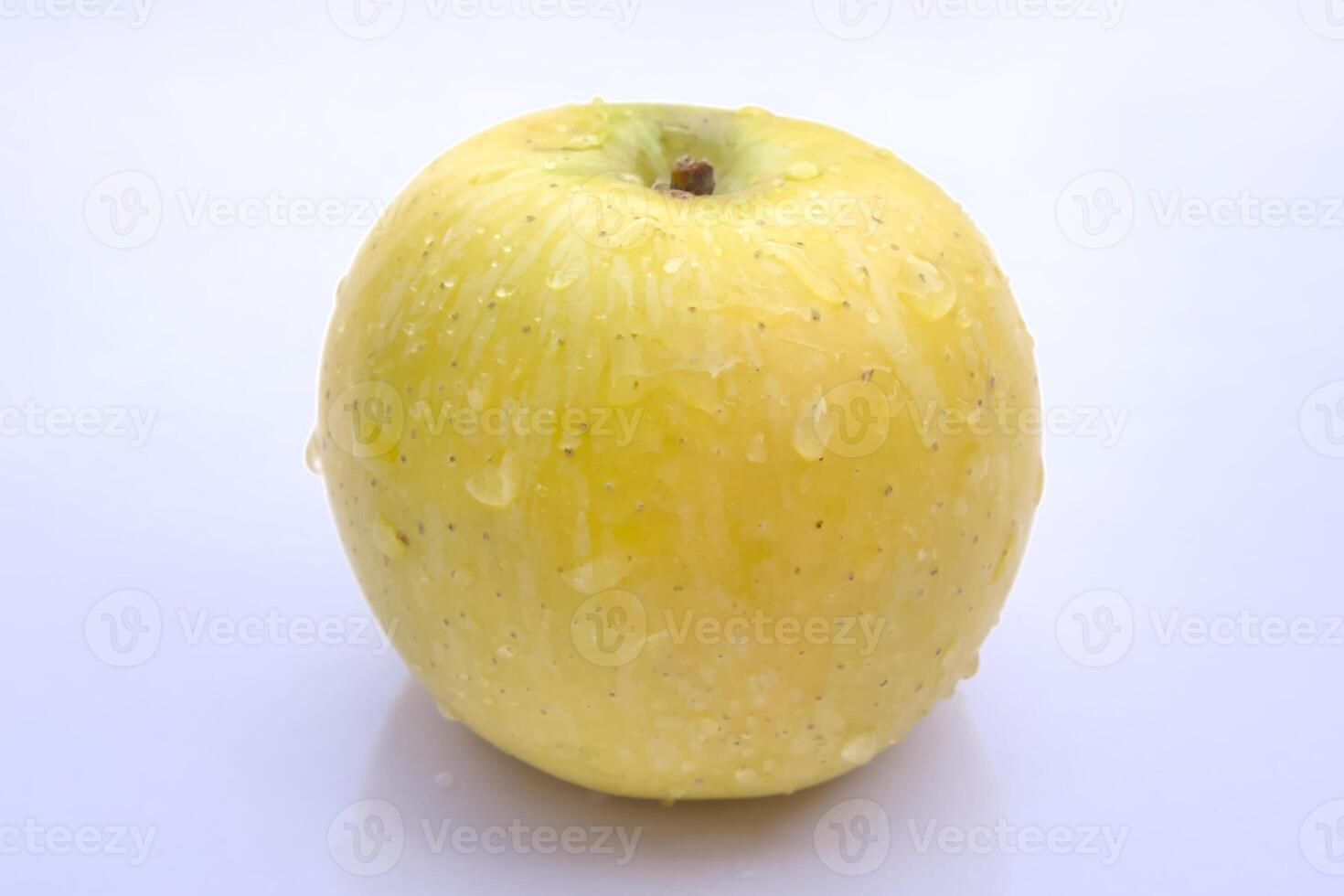 Fresh Golden Delicious Apple with Water Droplets, Close-Up Isolated on White Background photo