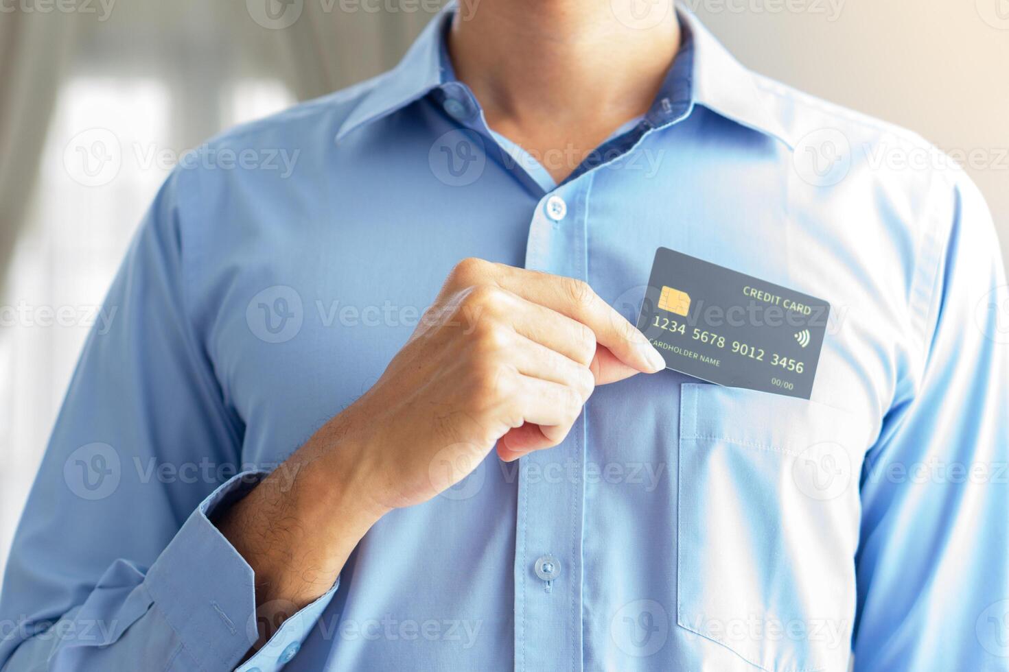 business man with blue suits showing mockup black credit card with blurry background photo