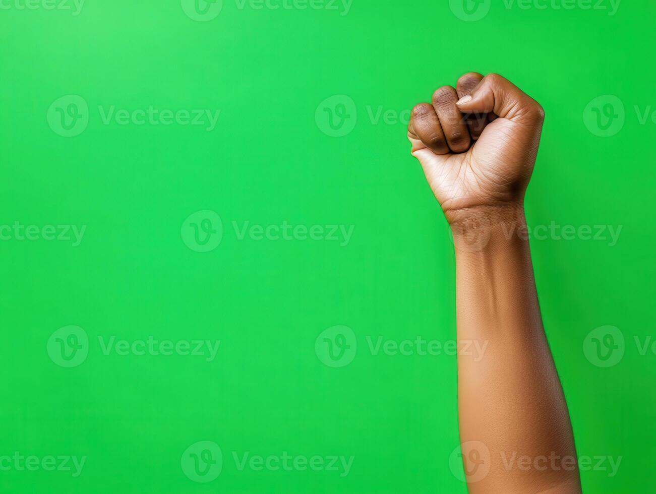 Raised Fist Against Green Background Symbolizing Strength, Unity, and Empowerment in a Minimalist Style photo