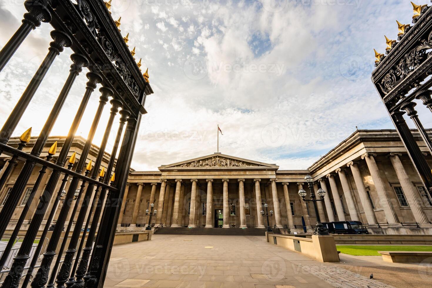 The British Museum grand neoclassical facade in London features towering columns and symmetrical design, standing proudly under an expansive sky. photo