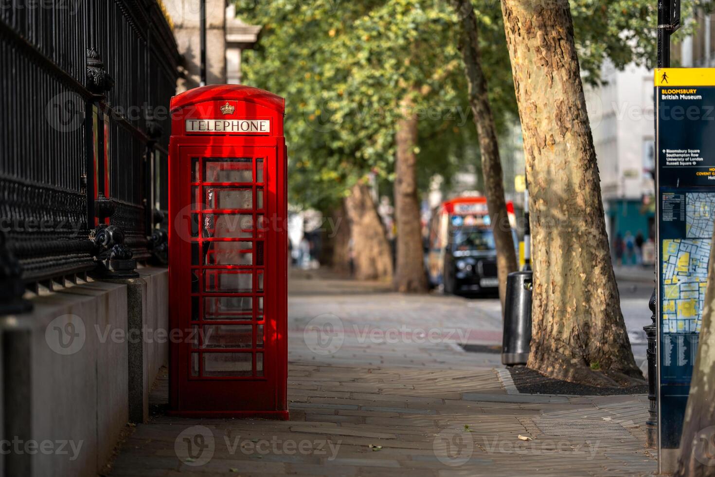A red telephone booth on a peaceful London side walk photo