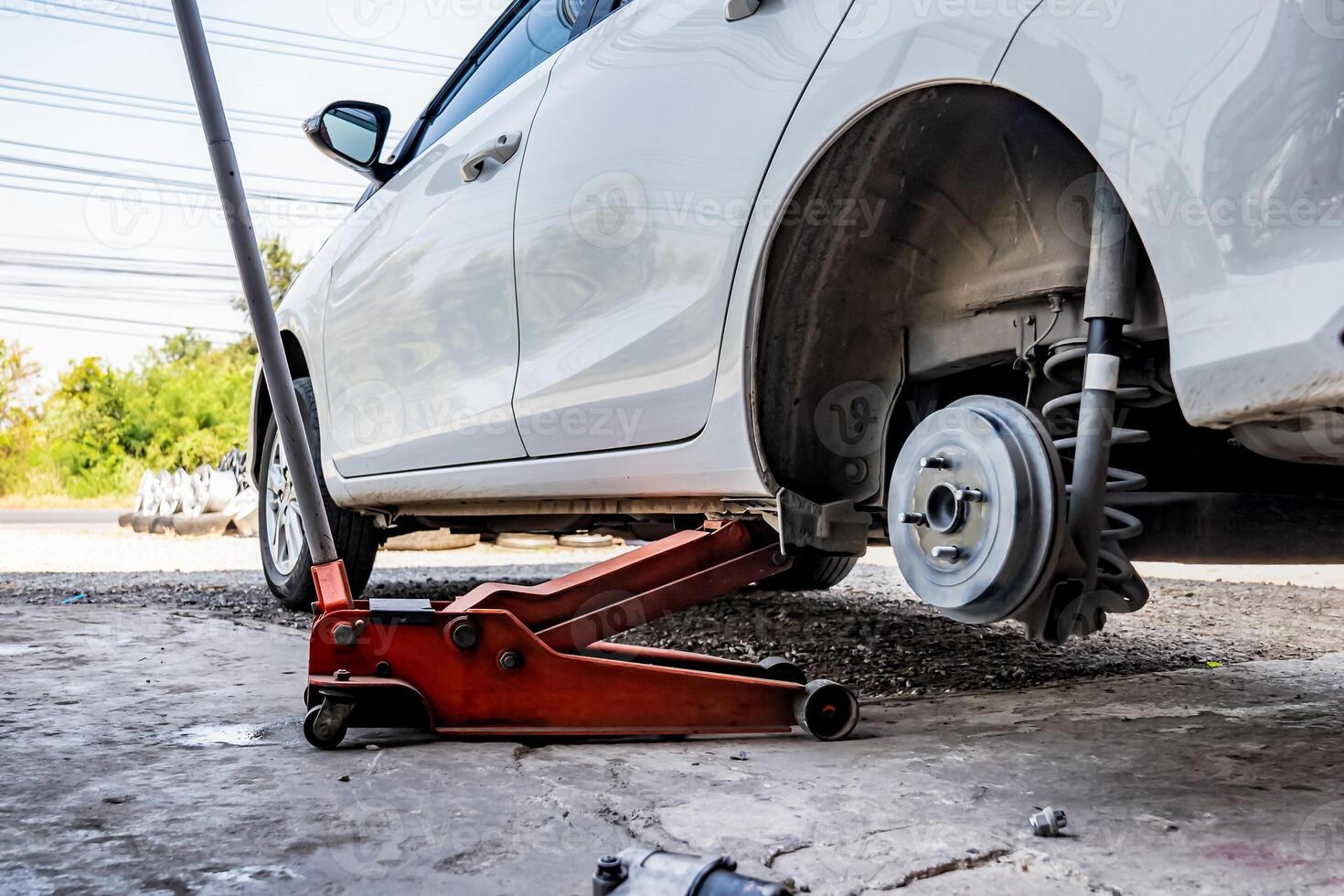 close up to the Fixing of broken tire with white car I n Thailand local garage. photo