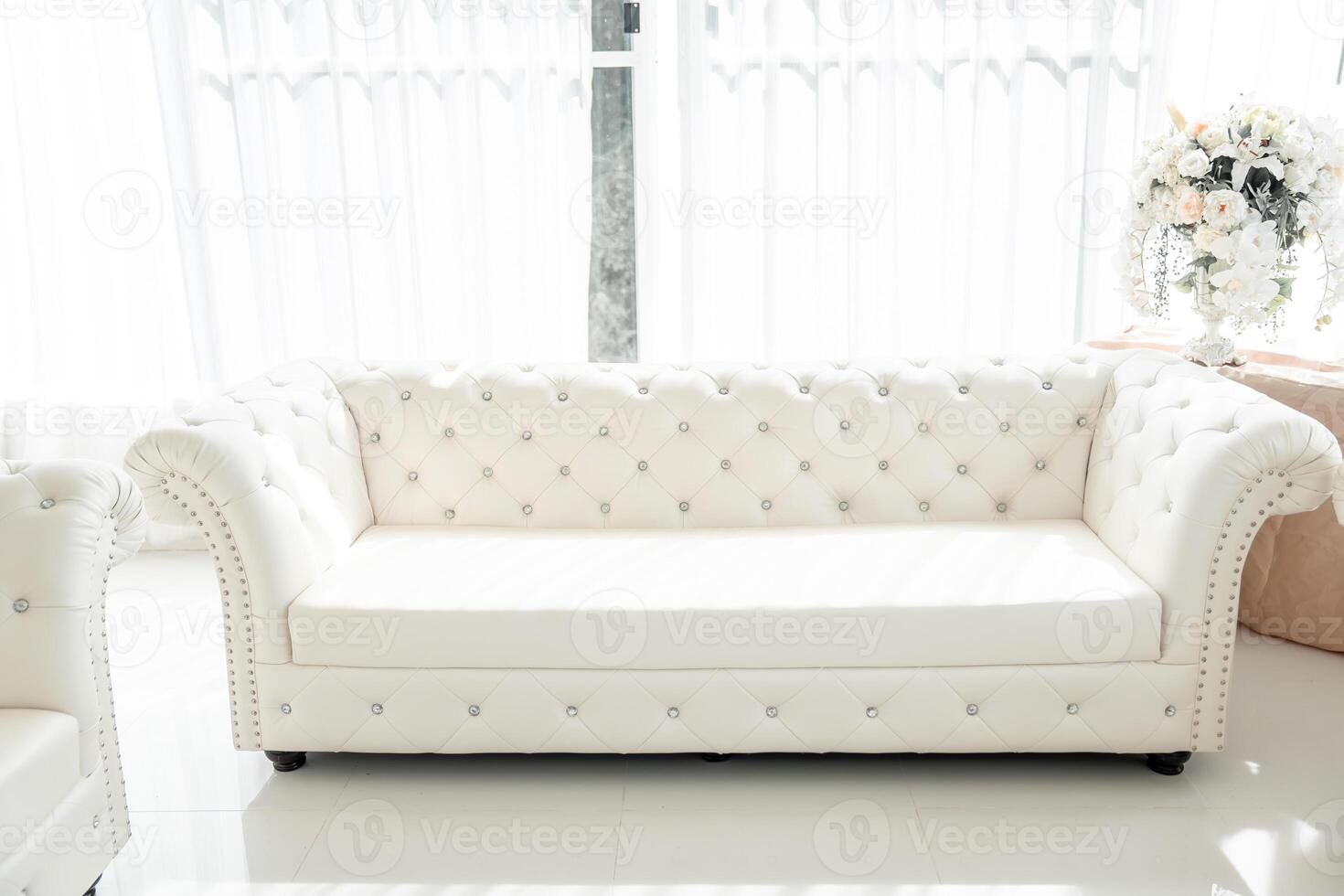 In a room that sparkles with mirrored walls and sun drenched light, a sophisticated sofa set exudes elegance and style. photo