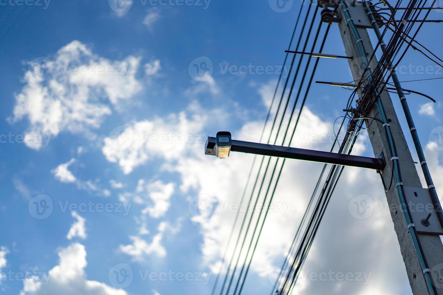 cctv camera is installed on the M etal stick that hung on to electric pole beside the street in village for monitoring and running safety system control in that area. photo