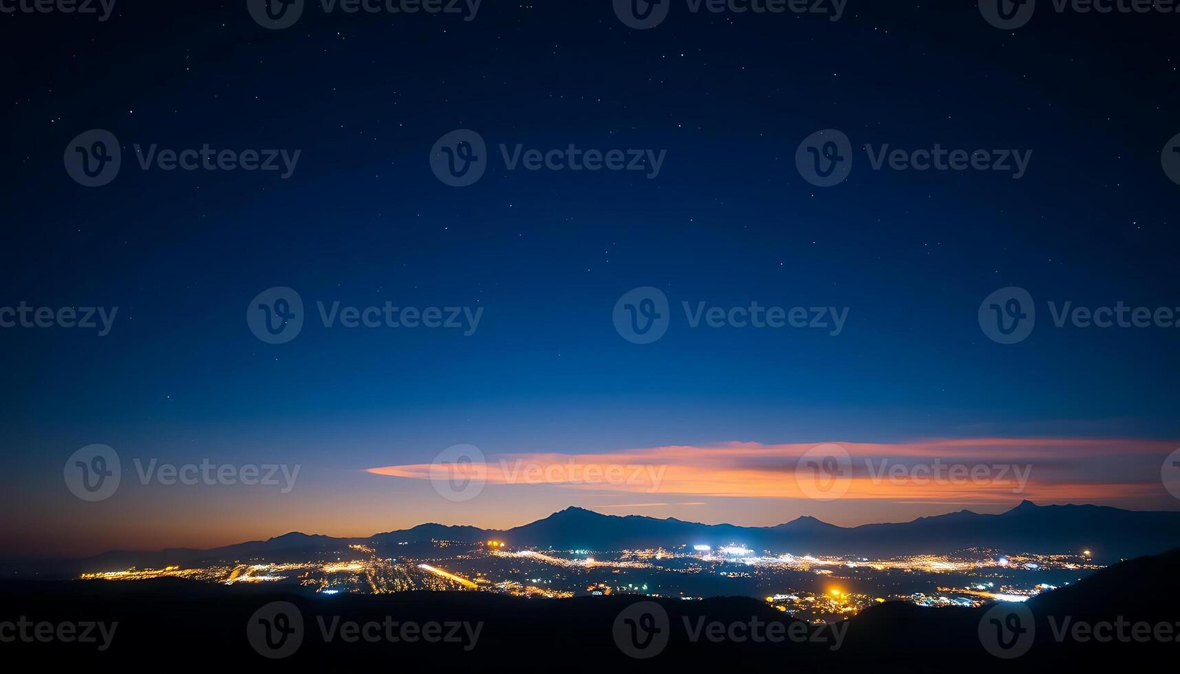 Stunning Night Sky Over a City with Distant Mountains and Colorful Clouds photo