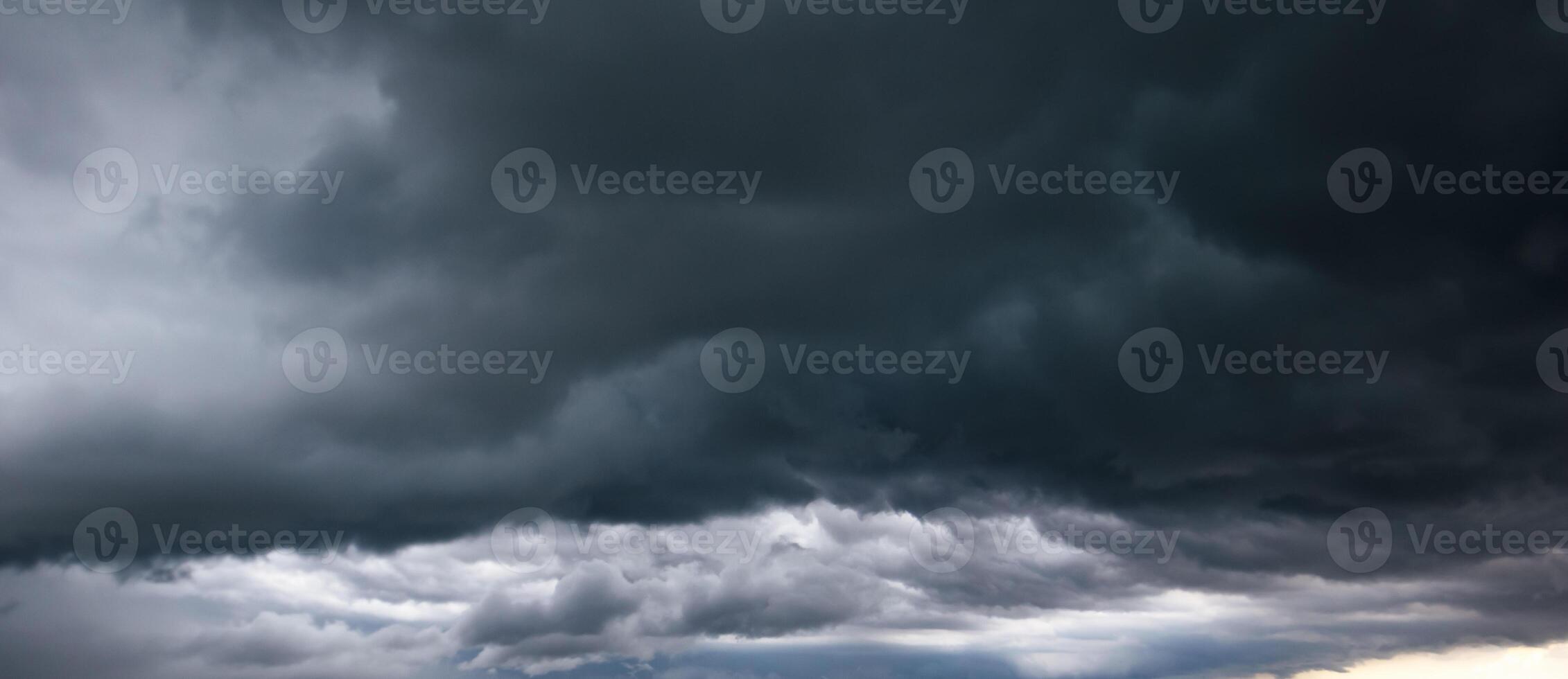 The dark sky with heavy cloud converging and a violent storm before the rain.Bad or moody weather sky and environment. carbon dioxide emissions, greenhouse effect, global warming, climate change photo