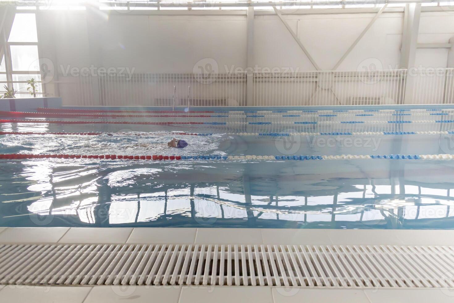 A 70-year-old pensioner is resting, swimming, recovering in th pool with clear and blue water in the hotel. photo