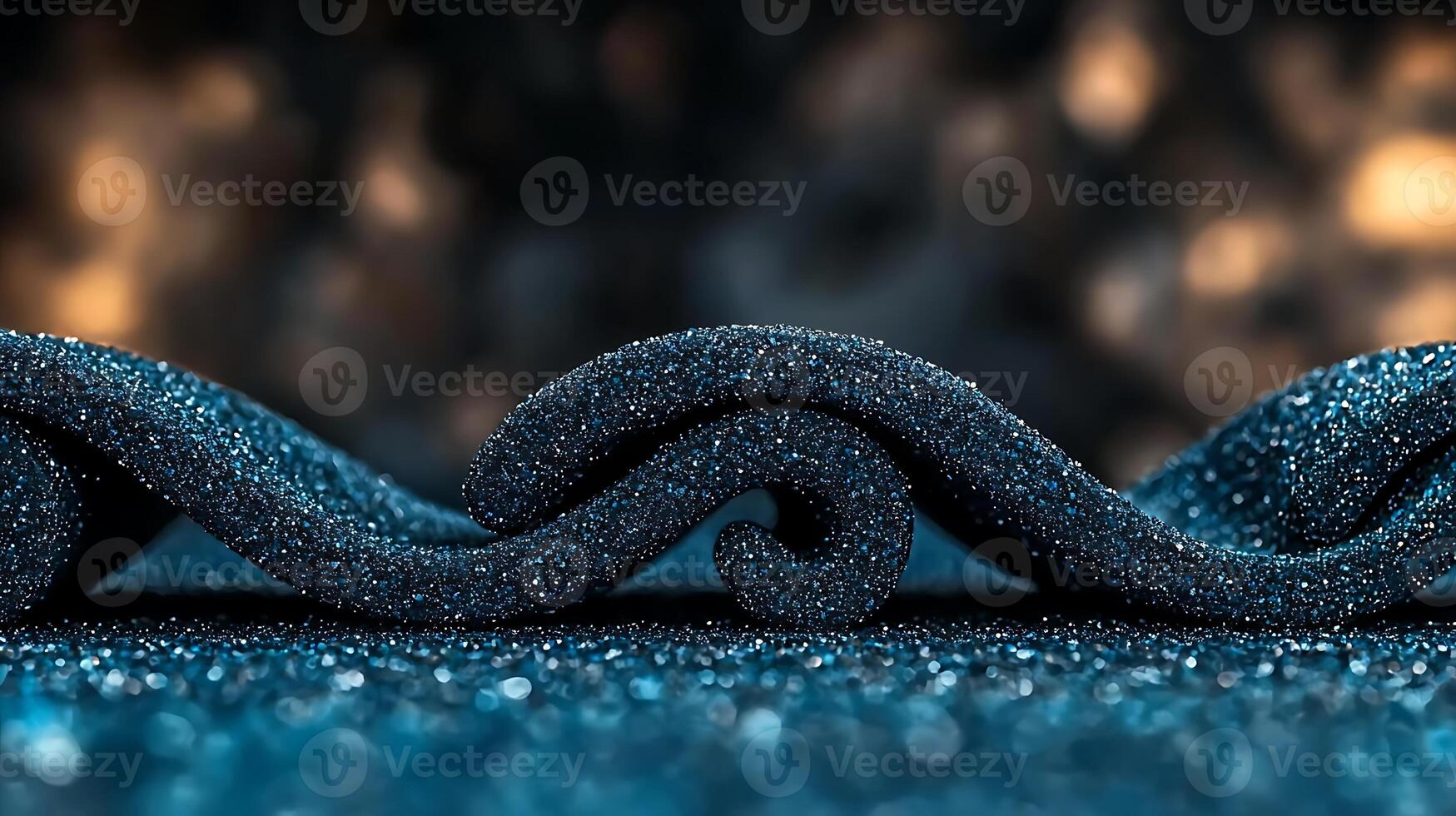 Close-up of textured black wave patterns on a sparkling blue surface with blurred background photo