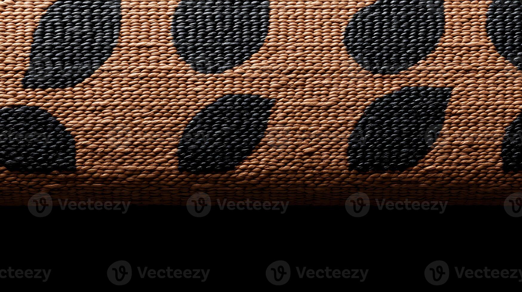 Close-up of textured fabric with bold black patterns on a warm brown background photo