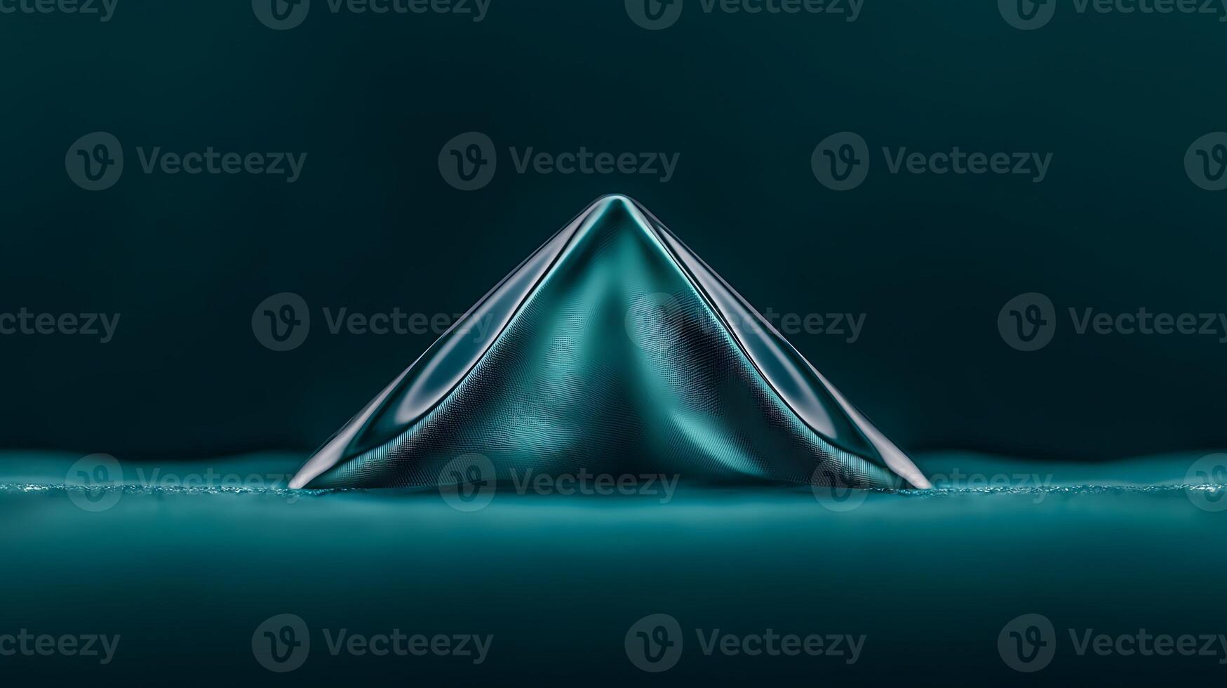 Close-up view of a sleek, teal pyramid shape on a smooth surface, showcasing fluid dynamics photo