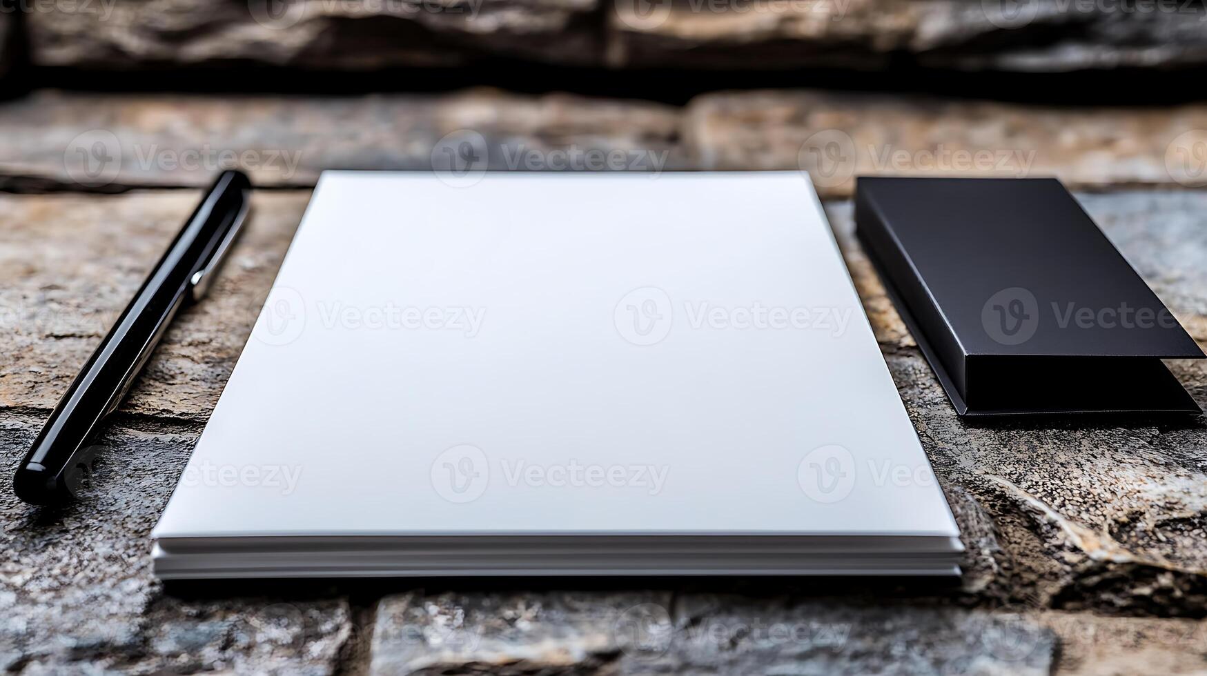 A blank notepad and pen on a textured stone surface, ideal for creative brainstorming sessions photo