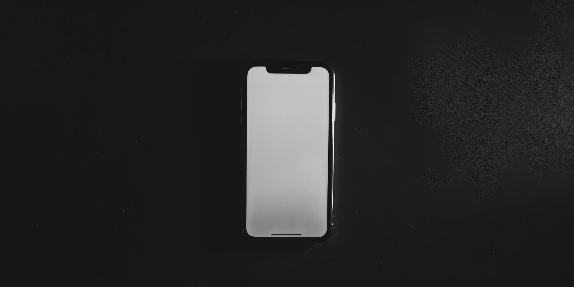 An iphone on a black surface with a blank screen photo