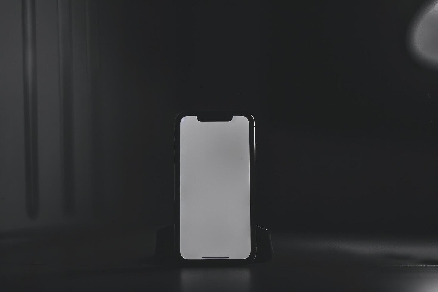 An iphone is sitting on a table in a dark room photo