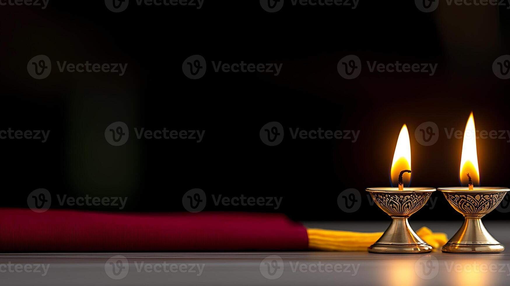 Two lit oil lamps on a table with a maroon cloth, creating a warm ambiance in a dark setting photo