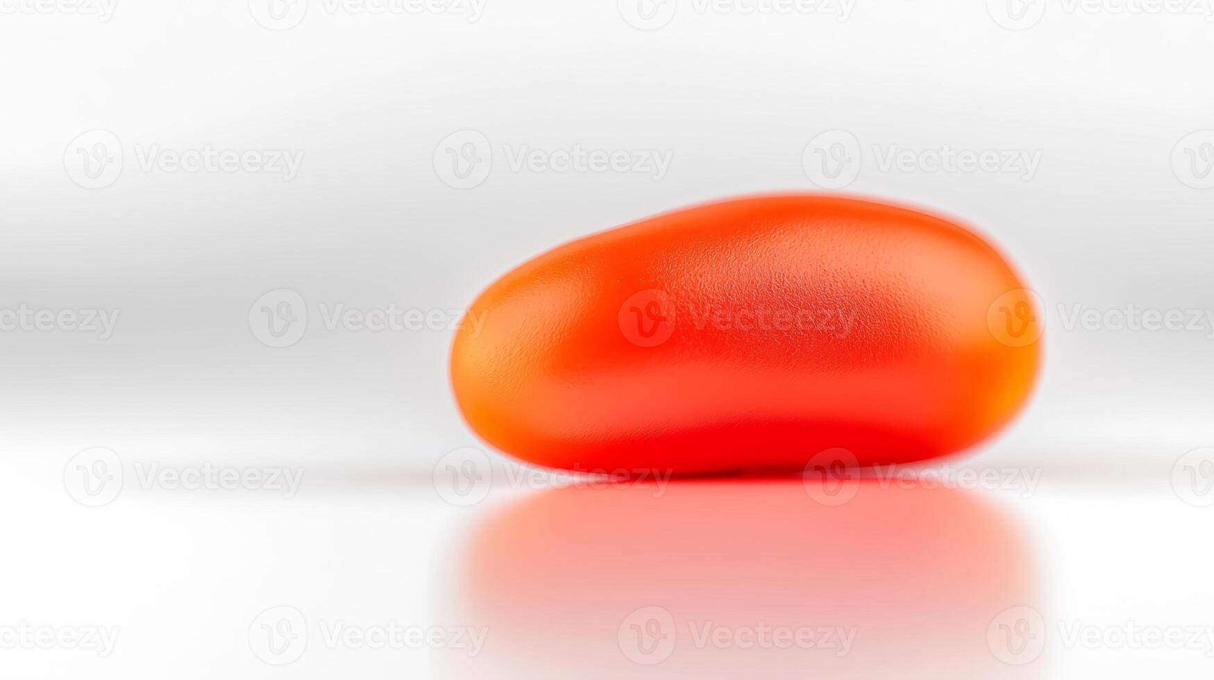 A smooth, shiny red object resembling a bean, placed on a reflective surface with soft lighting photo