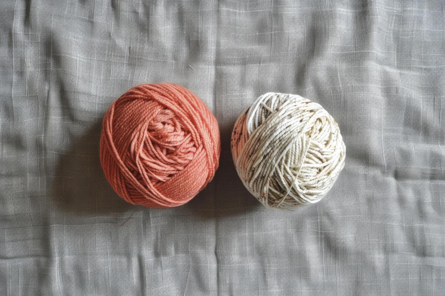 light orange and white colour two yarn ball and background is a gray linen fabric photo