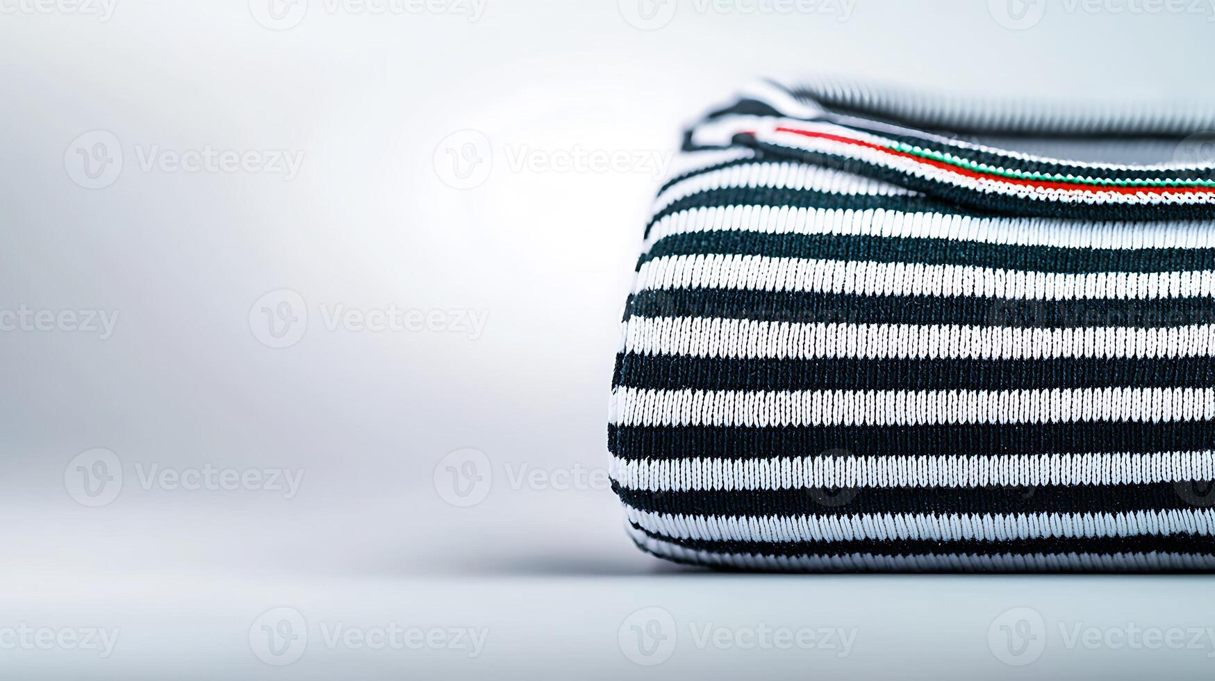 Striped fabric bag resting on a smooth surface with a minimalist background photo