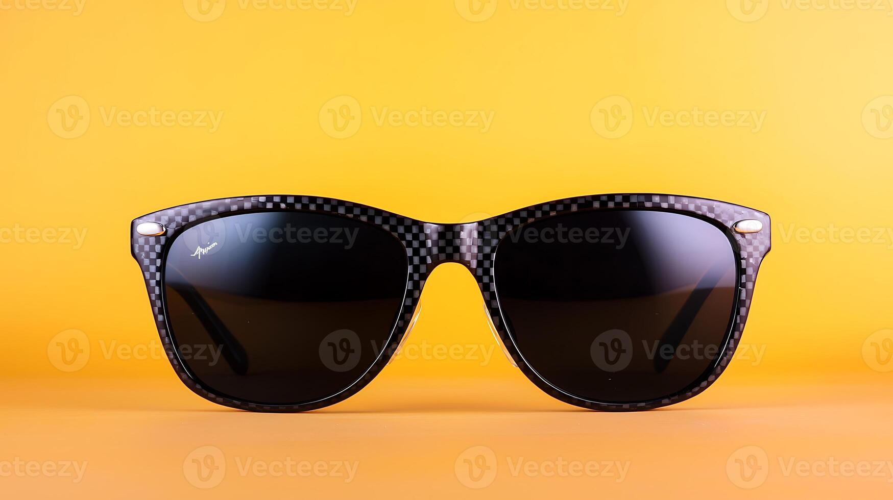 Stylish black sunglasses with a carbon fiber design against a vibrant yellow background photo