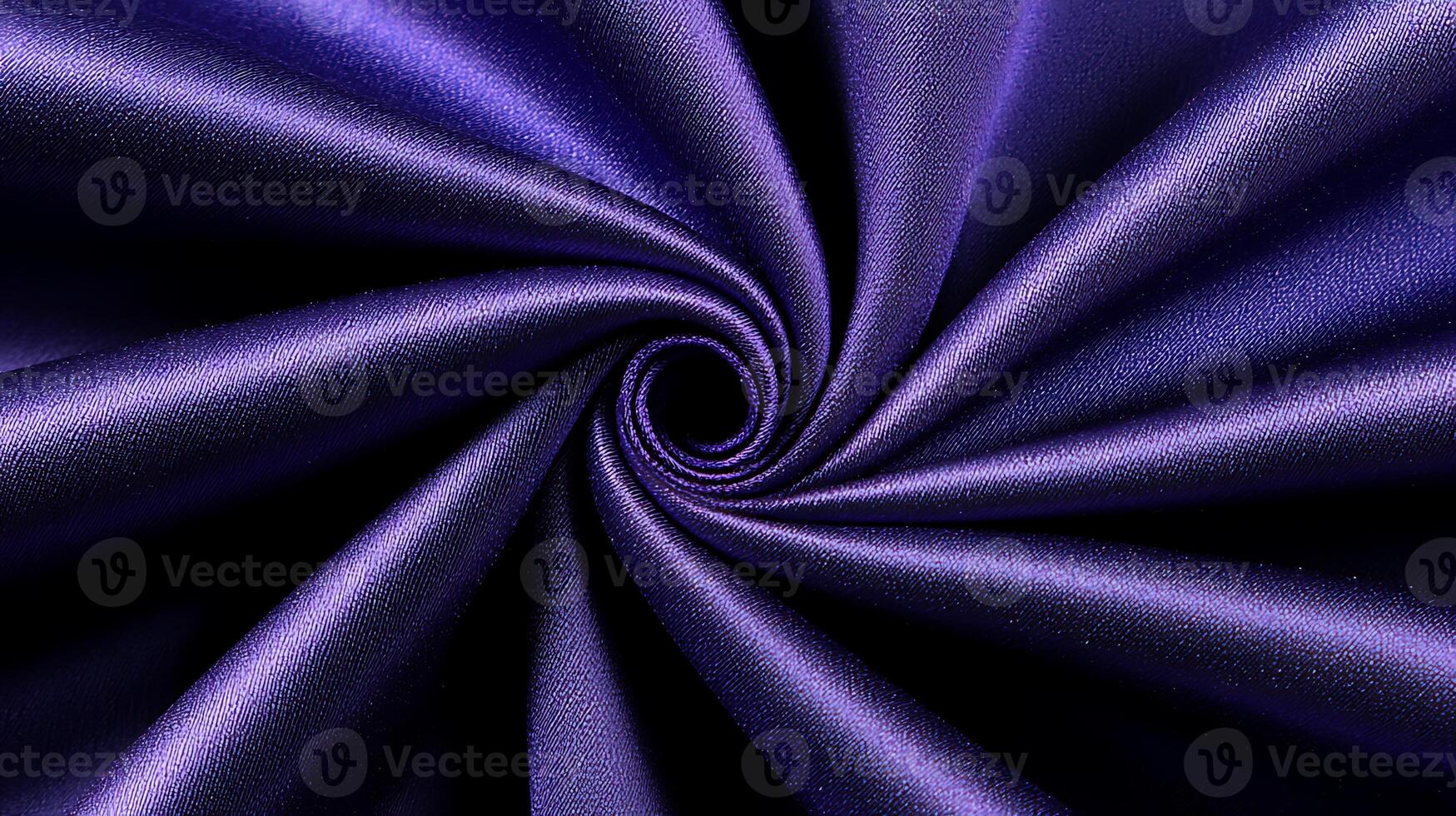 Close-up of a swirling purple fabric showcasing smooth texture and rich color depth photo