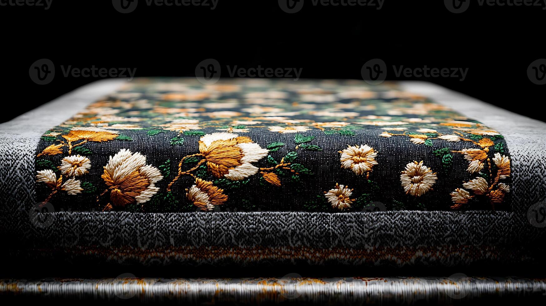 Close-up of intricately embroidered fabric showcasing floral patterns against a dark background photo