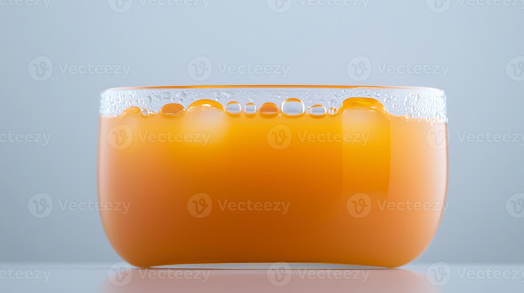 Close-up of a translucent bowl filled with orange juice, showcasing bubbles and smooth texture photo
