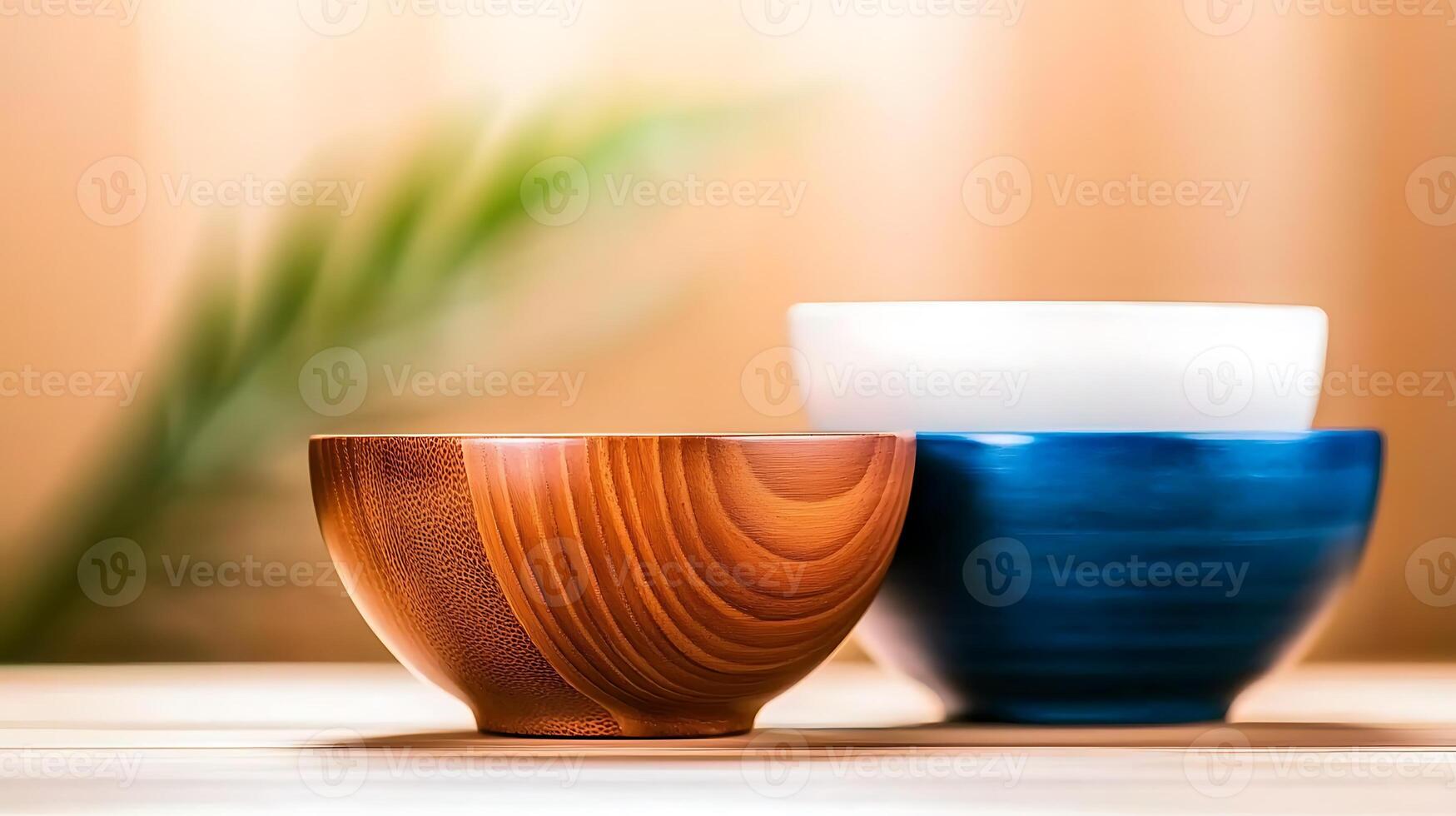 Three beautifully crafted bowls in warm tones arranged on a wooden surface with a blurred background photo
