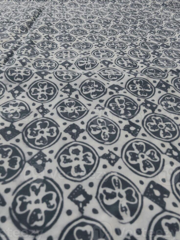 a black and white patterned fabric with a large flower on it photo