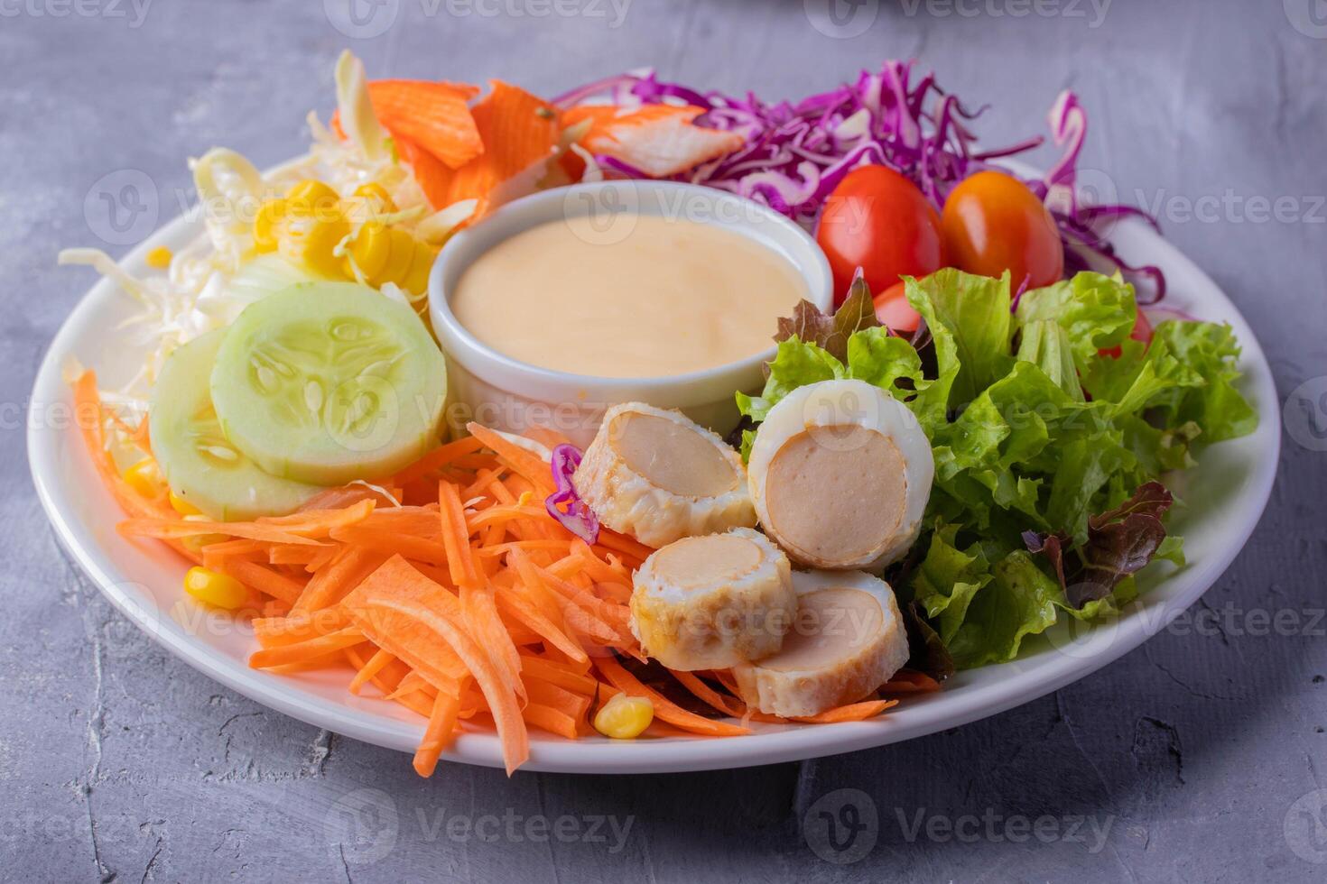 vibrant salad plate featuring fresh vegetables like lettuce, carrots, cucumber, cherry tomatoes, and purple cabbage, accompanied by sliced boiled eggs and creamy dressing in center photo