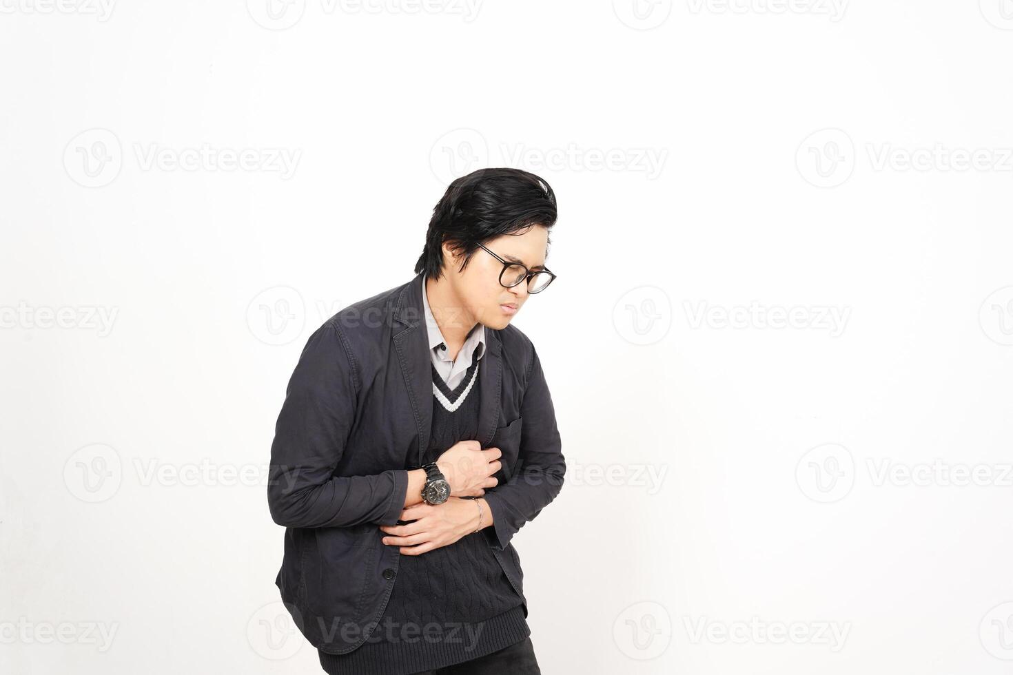 A man in glasses and a sweater is standing in front of a white wall photo