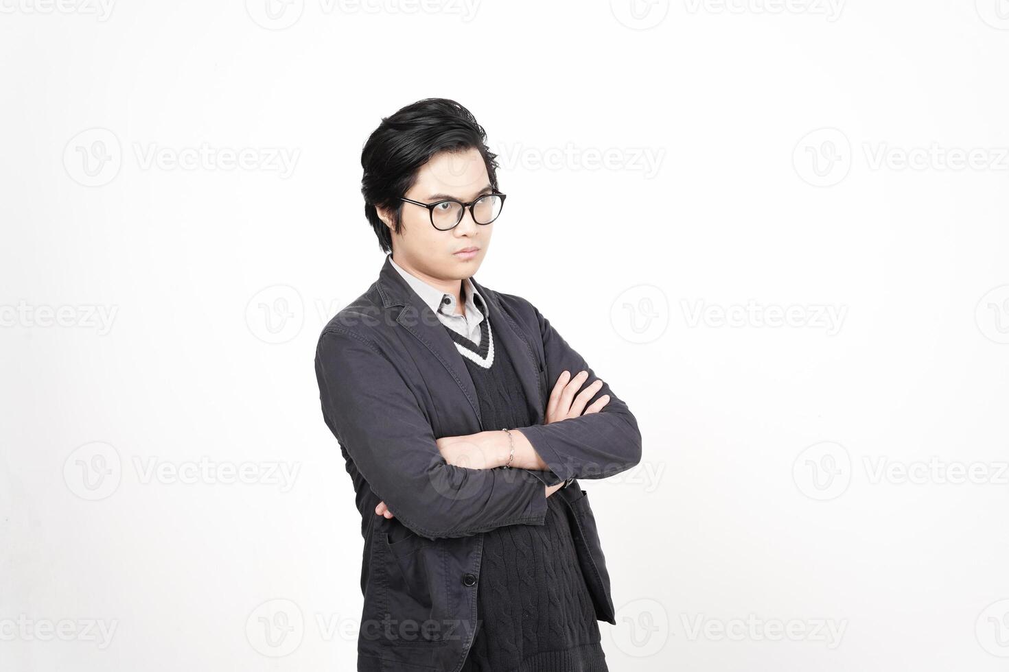 A man in glasses and a jacket standing with his arms crossed photo