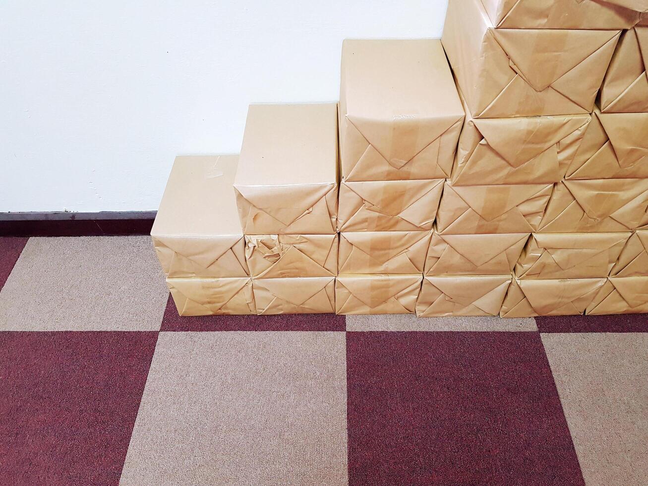 Many stack of brown package boxes on the purple rug and white wall with copy space. Packaging store for business book store photo