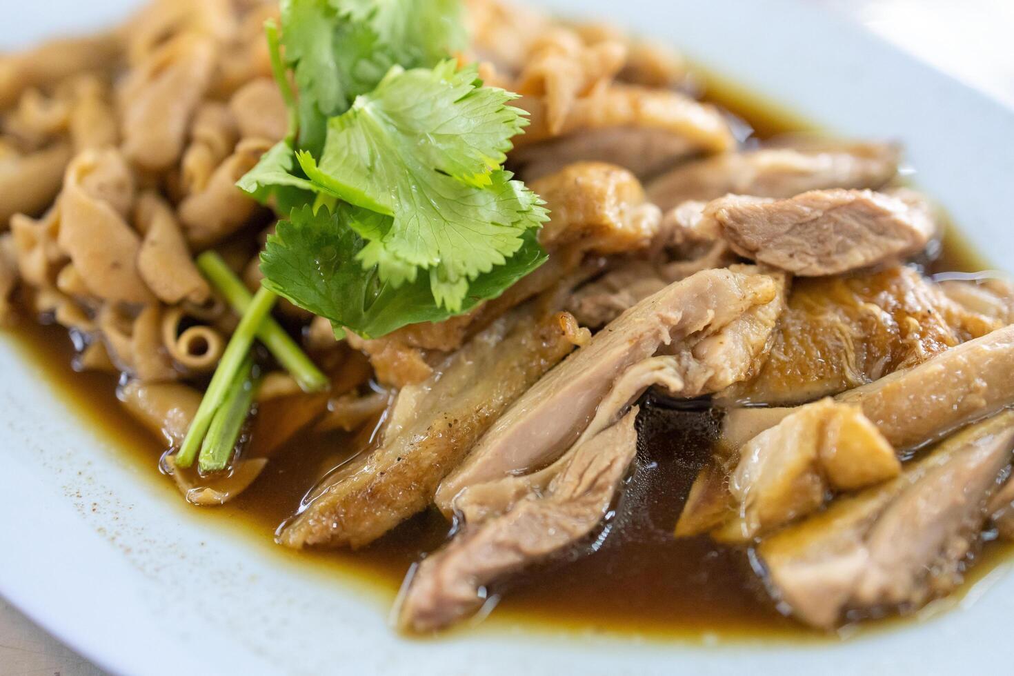 View chop boiled duck and stew intestine in brown soy soup dipping spicy sauce, focus selective photo