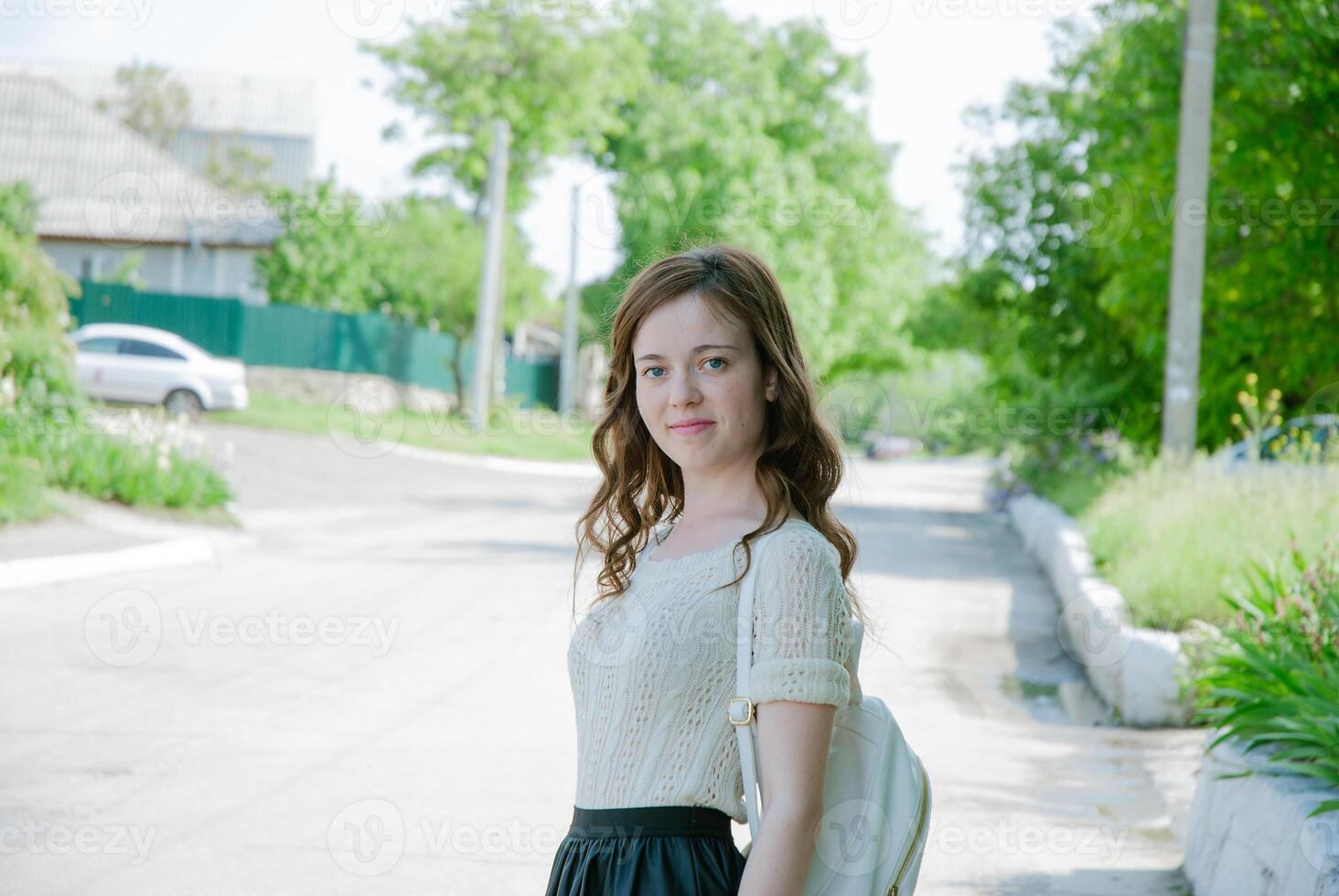 Caucasian young female smiling outdoors on a sunny day in residential area photo