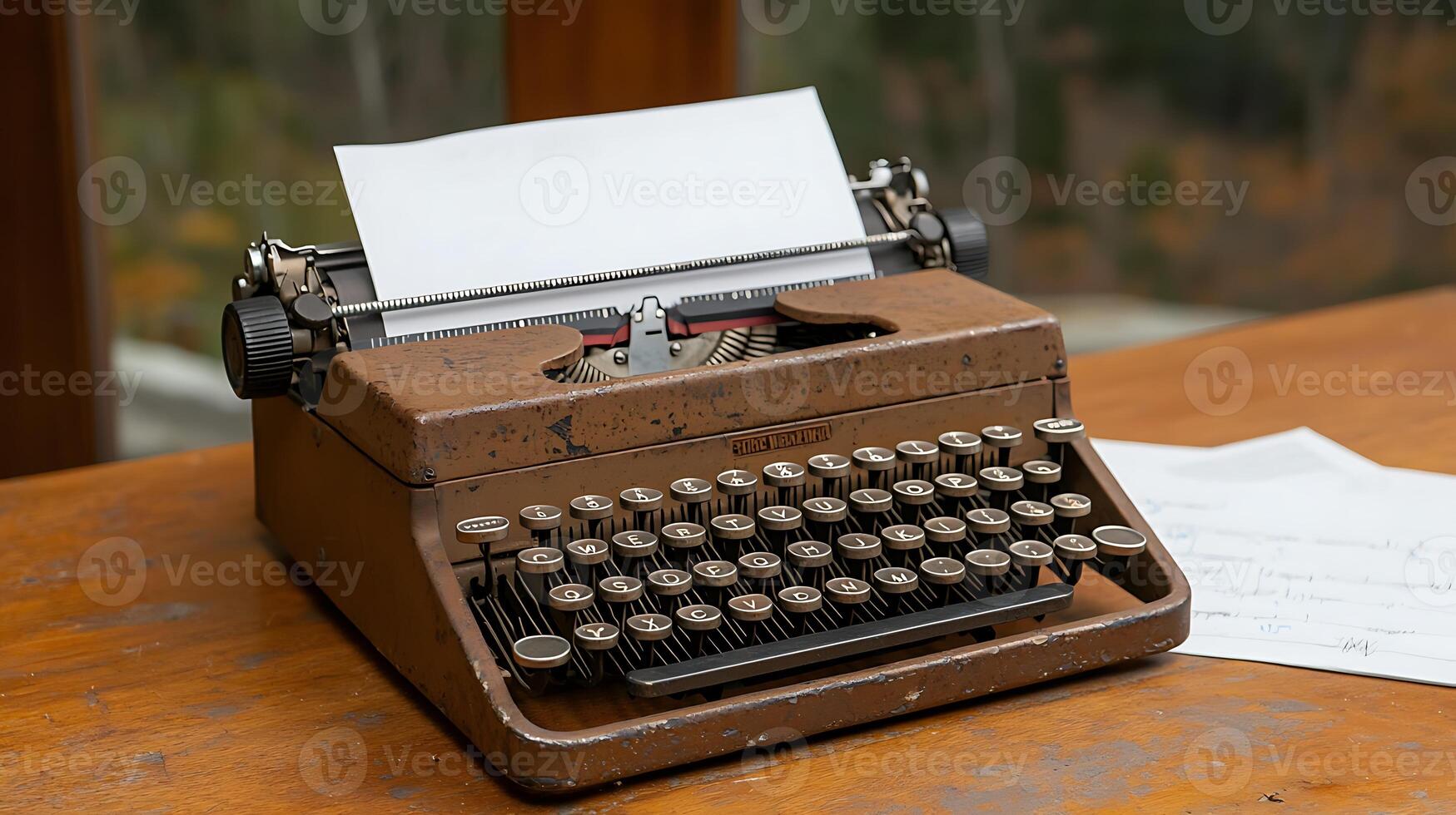 Vintage typewriter on a wooden table with blank paper, surrounded by autumn scenery outside photo