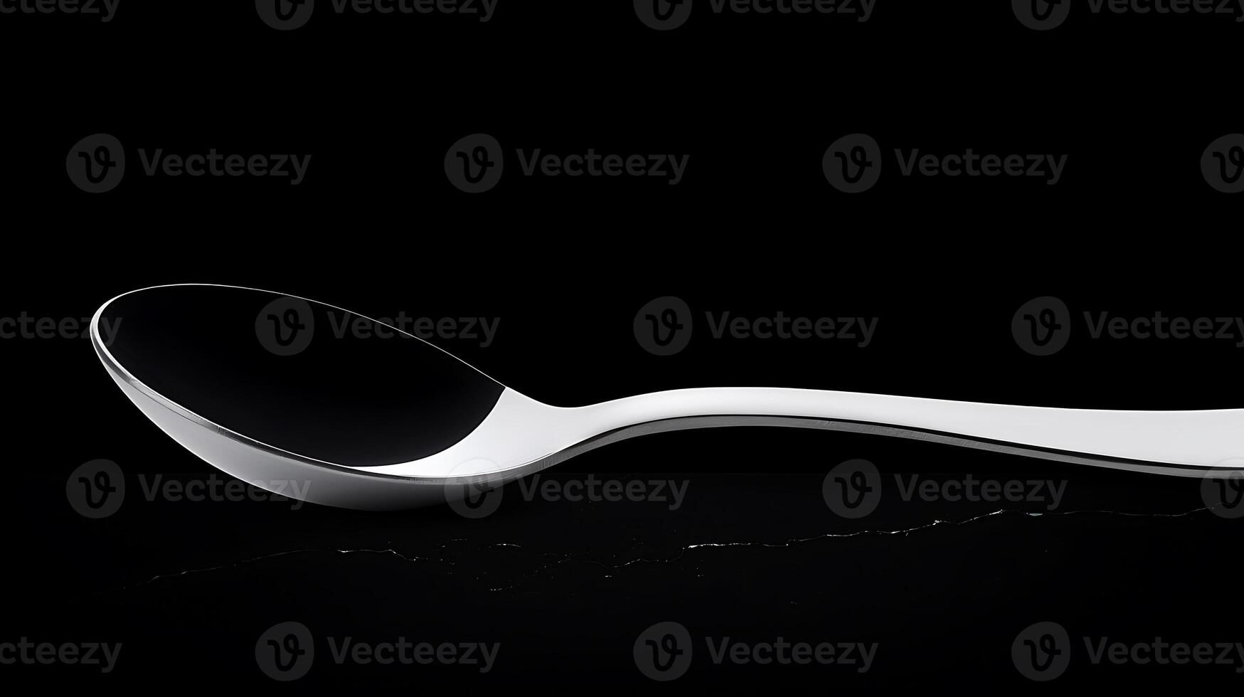 Sleek silver spoon resting on a dark surface, highlighting its reflective qualities and design photo
