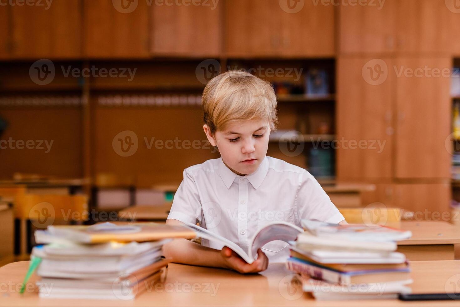 Schoolboy in glasses with visual impairment answering in school lesson photo