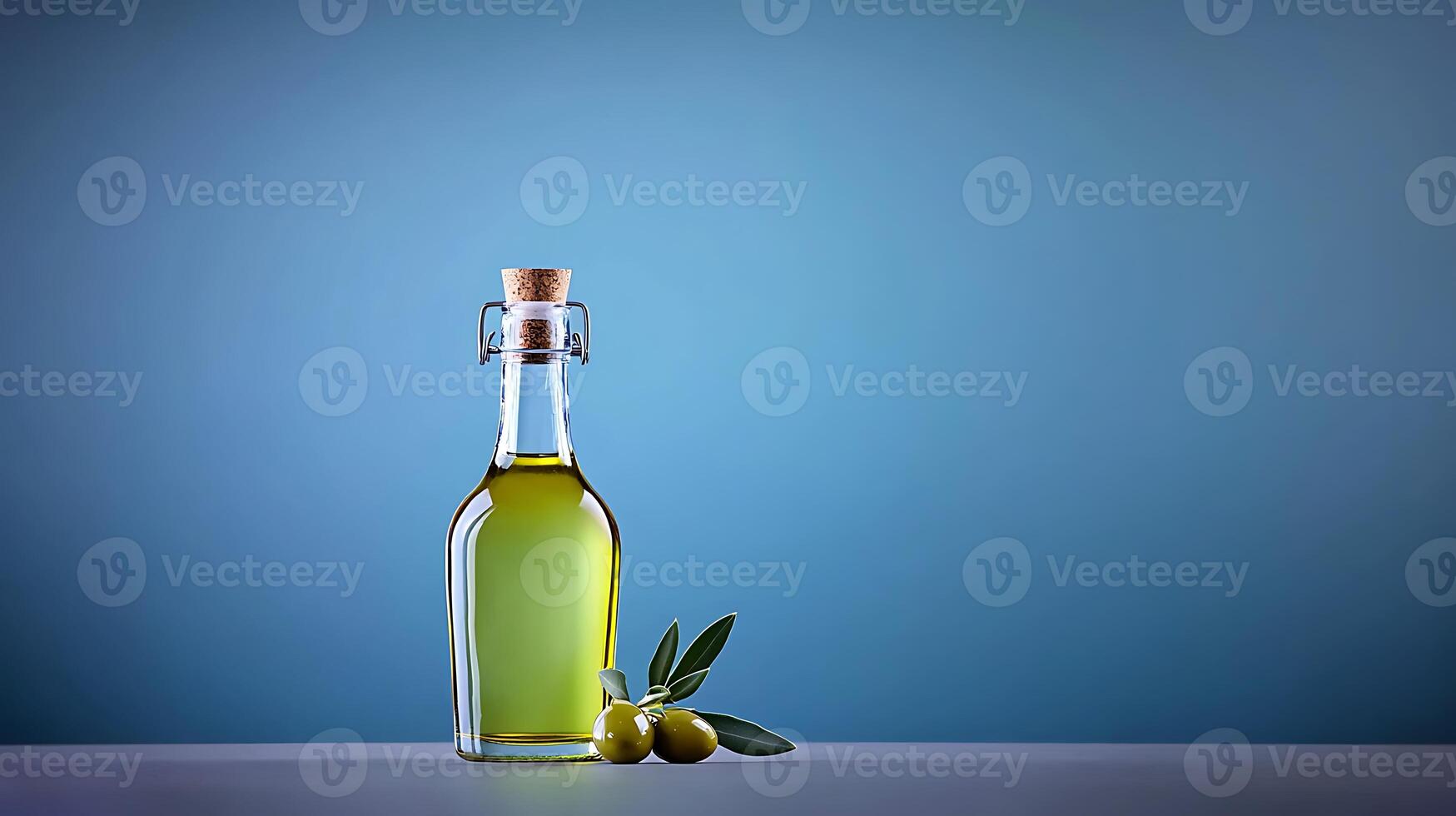 A glass bottle of olive oil with fresh olives and leaves on a minimalist blue background photo