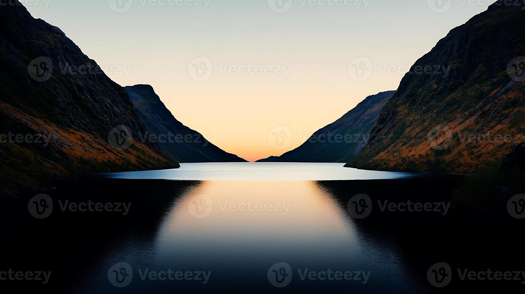 Serene twilight over a tranquil lake surrounded by majestic mountains and fading light photo