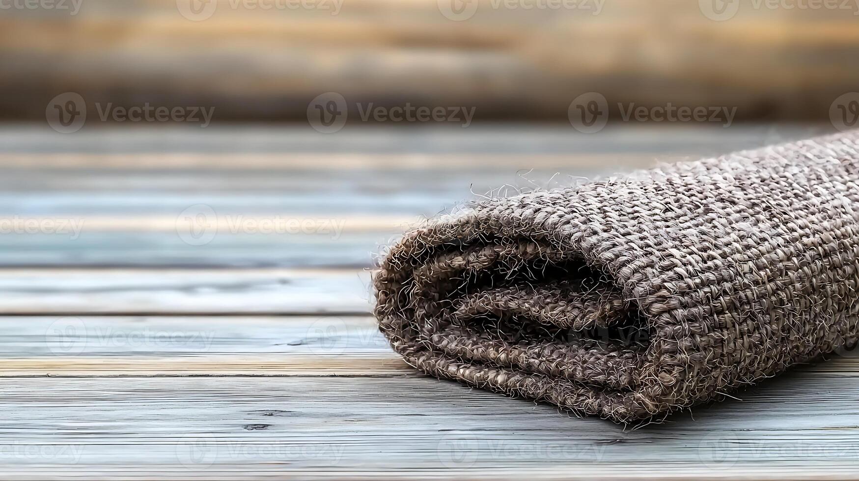 Rolled burlap fabric resting on a wooden surface, showcasing a rustic and natural aesthetic photo