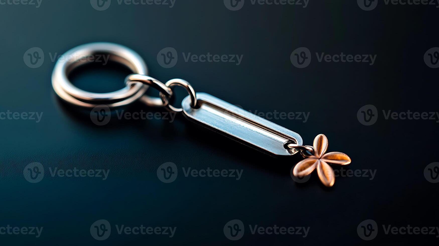 Close-up of a metallic keychain with a floral charm against a dark background, showcasing details photo