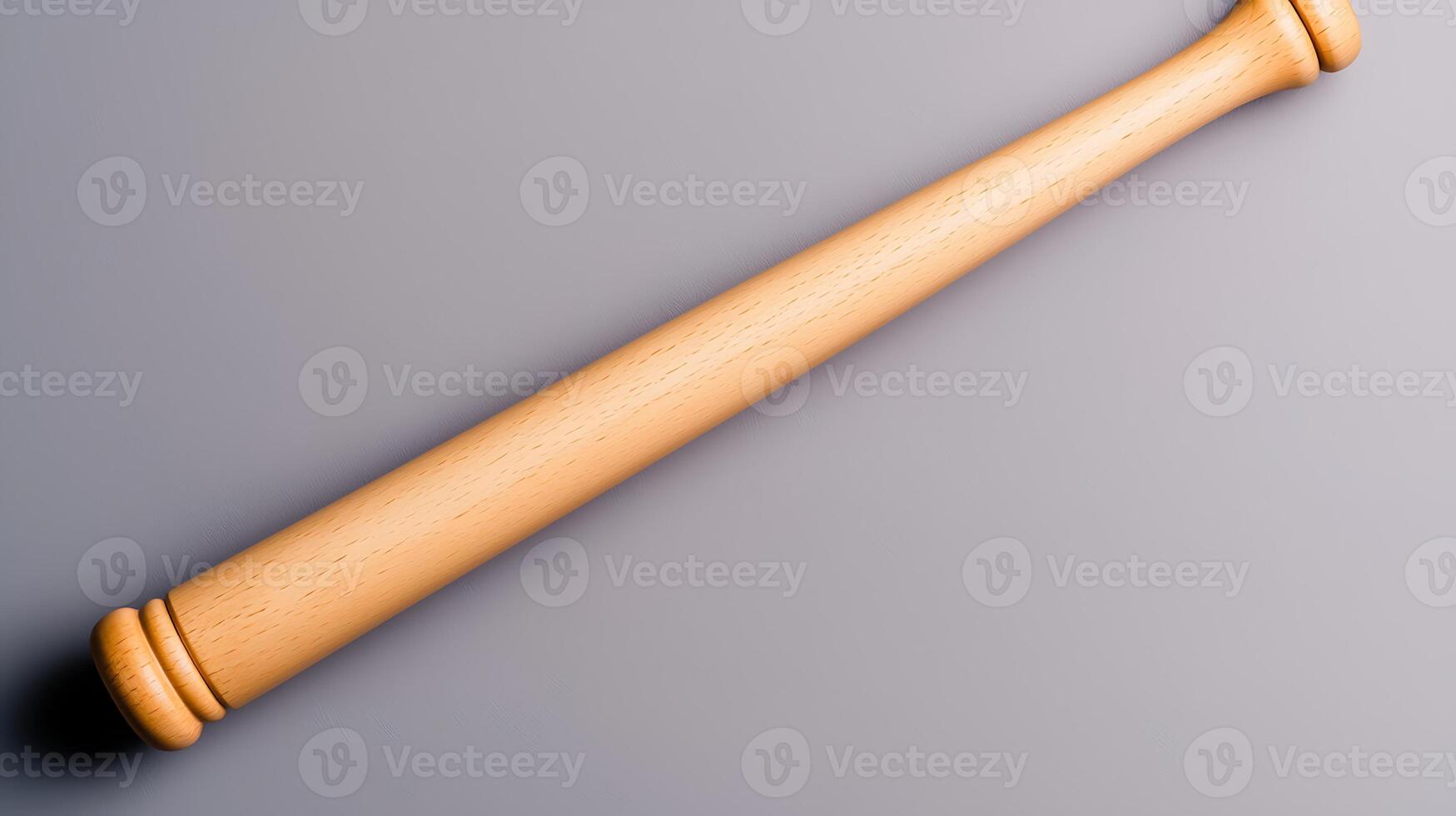 A close-up view of a wooden baseball bat resting on a smooth gray surface, ideal for sports themes photo