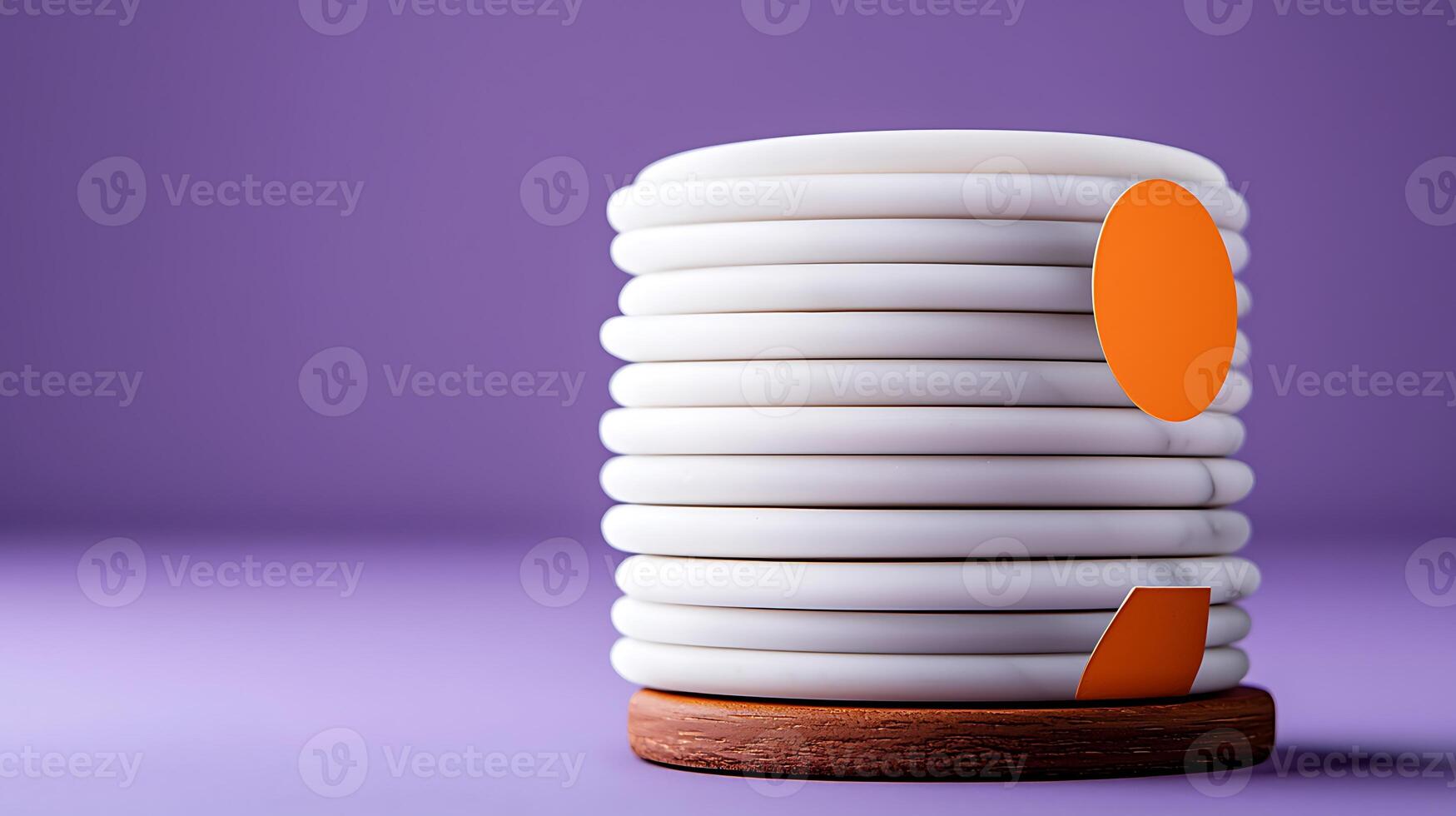 Stack of white plates with orange accents on a wooden base against a purple background photo