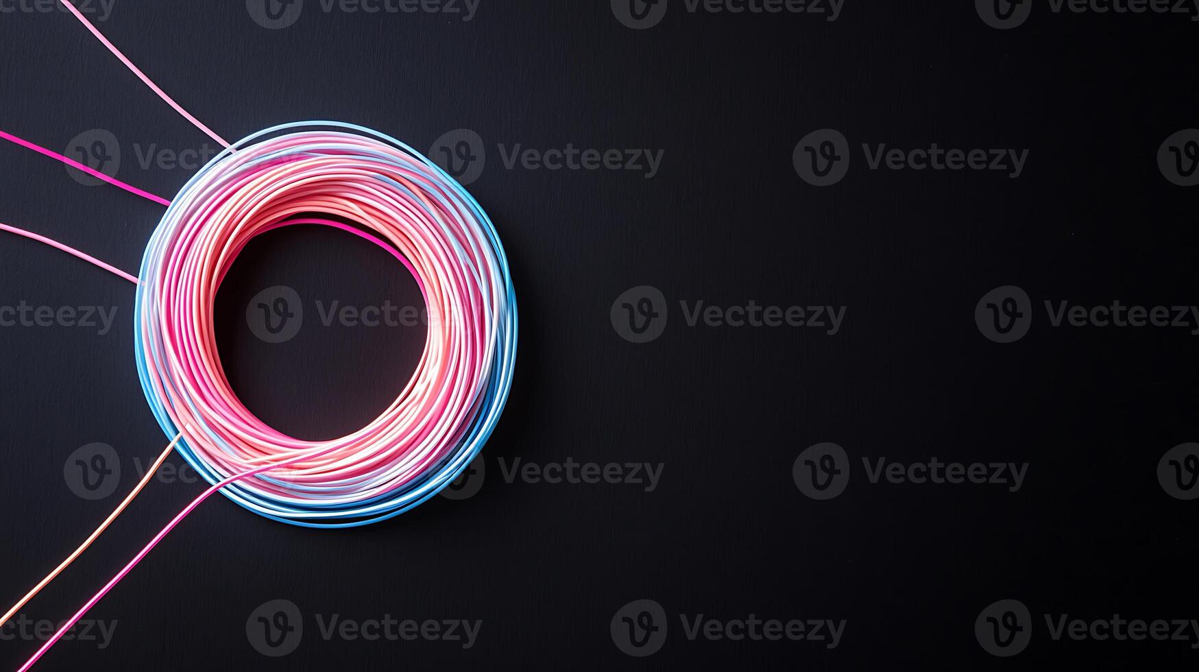 Vibrant colored wires coiled on a dark background, showcasing creativity and design potential photo