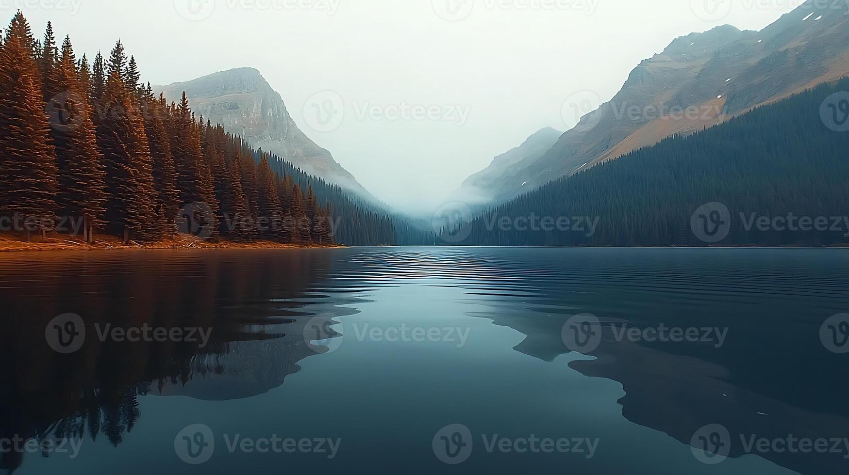 Serene lake reflecting misty mountains and autumn trees in a tranquil landscape at dusk photo