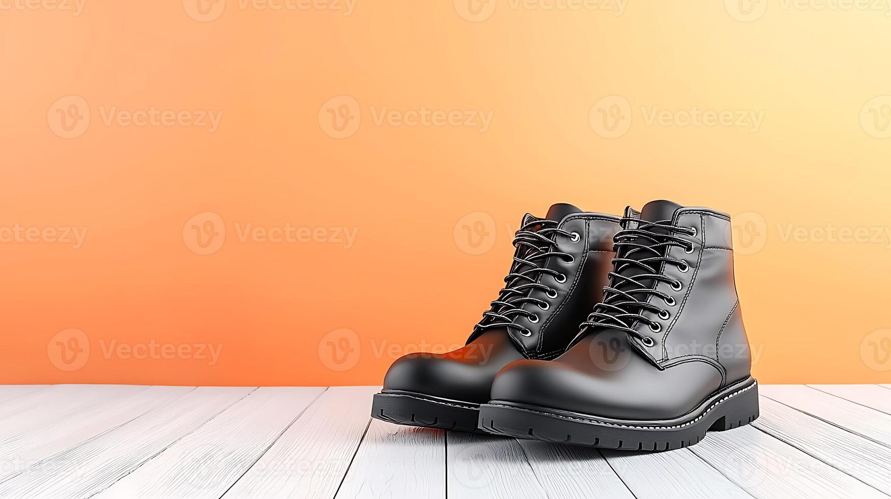 Stylish black leather boots on a wooden floor with an orange gradient background photo