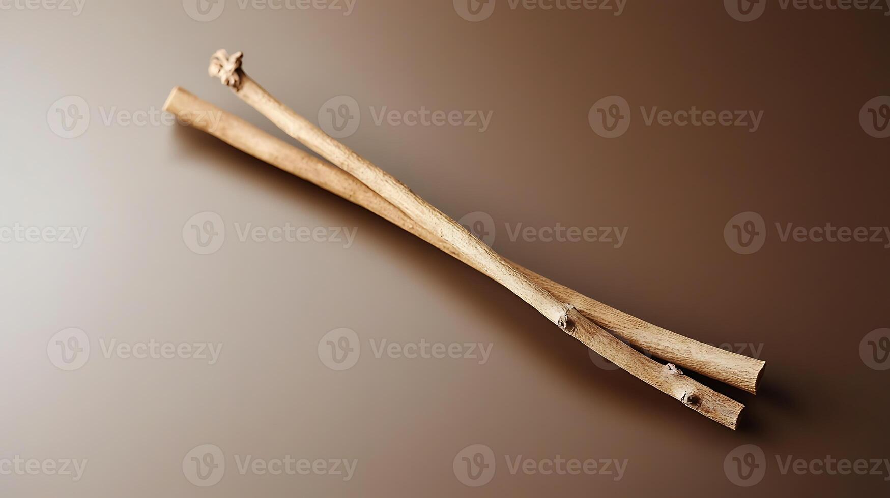Two rustic wooden sticks placed artistically on a smooth brown surface, showcasing natural textures photo