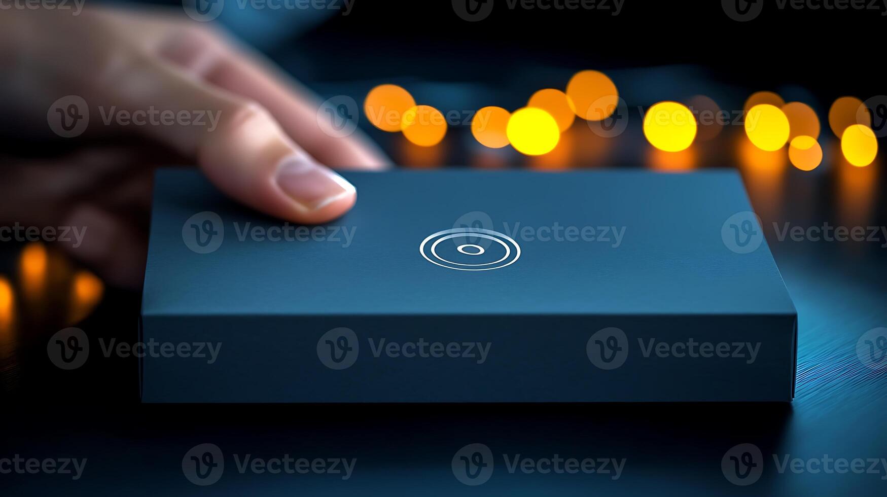 A person gently placing a sleek black box on a dark surface with glowing lights in the background photo