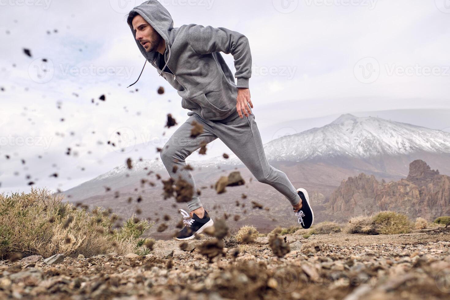 Hispanic man running fast in mountains photo